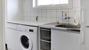 A laundry area with a washing machine, a sink, and a window above the sink. - 4 Star Holiday Home in Mellerud (Mellerud)
