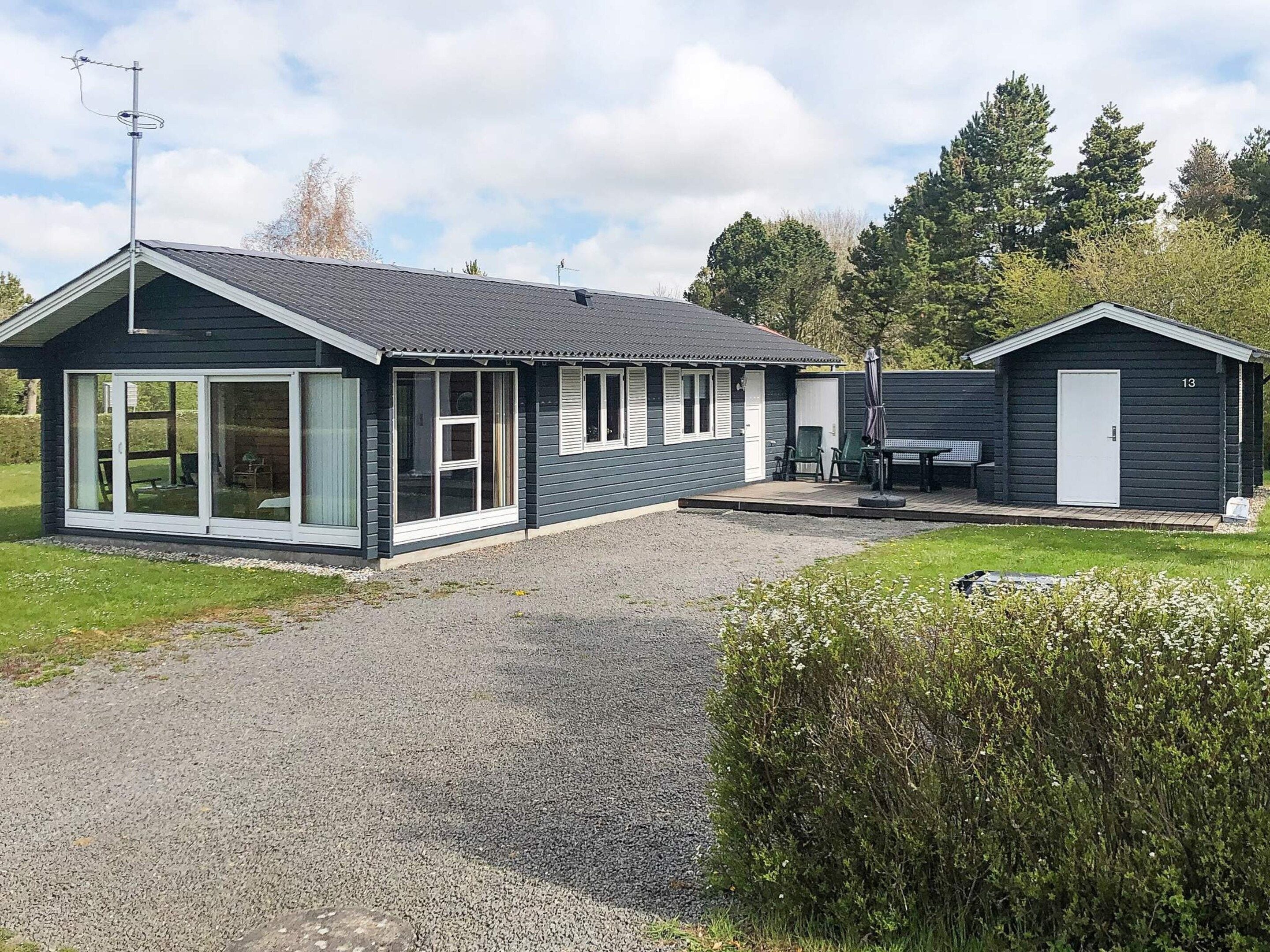 A two-story building with a gravel driveway and a grassy lawn.