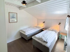 A room with two beds, a framed picture on the wall, and a ceiling light fixture. - 12 Person Holiday Home in Fano (Fano)