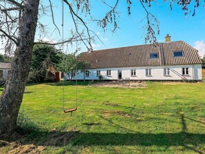 A white house with a tiled roof, a swing, and a grassy yard. - 4 Star Holiday Home in Aabybro (Aabybro)