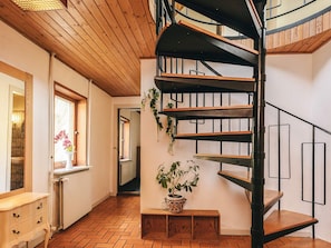 A spiral staircase with wooden steps and metal railings, leading to an upper floor. - 4 Star Holiday Home in Aabybro (Aabybro)