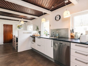 A modern kitchen with white cabinets, stainless steel appliances, and a wooden ceiling. - 4 Star Holiday Home in Aabybro (Aabybro)