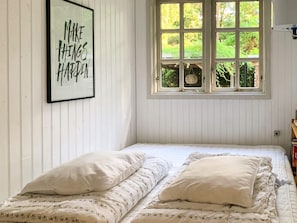 A room with a bed, a framed inspirational quote, and a window with a view of greenery. - 4 Star Holiday Home in Vejby (Vejby)