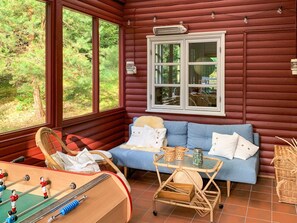 A cozy room with a sofa, a small table, and a foosball table. - 4 Star Holiday Home in Vejby (Vejby)
