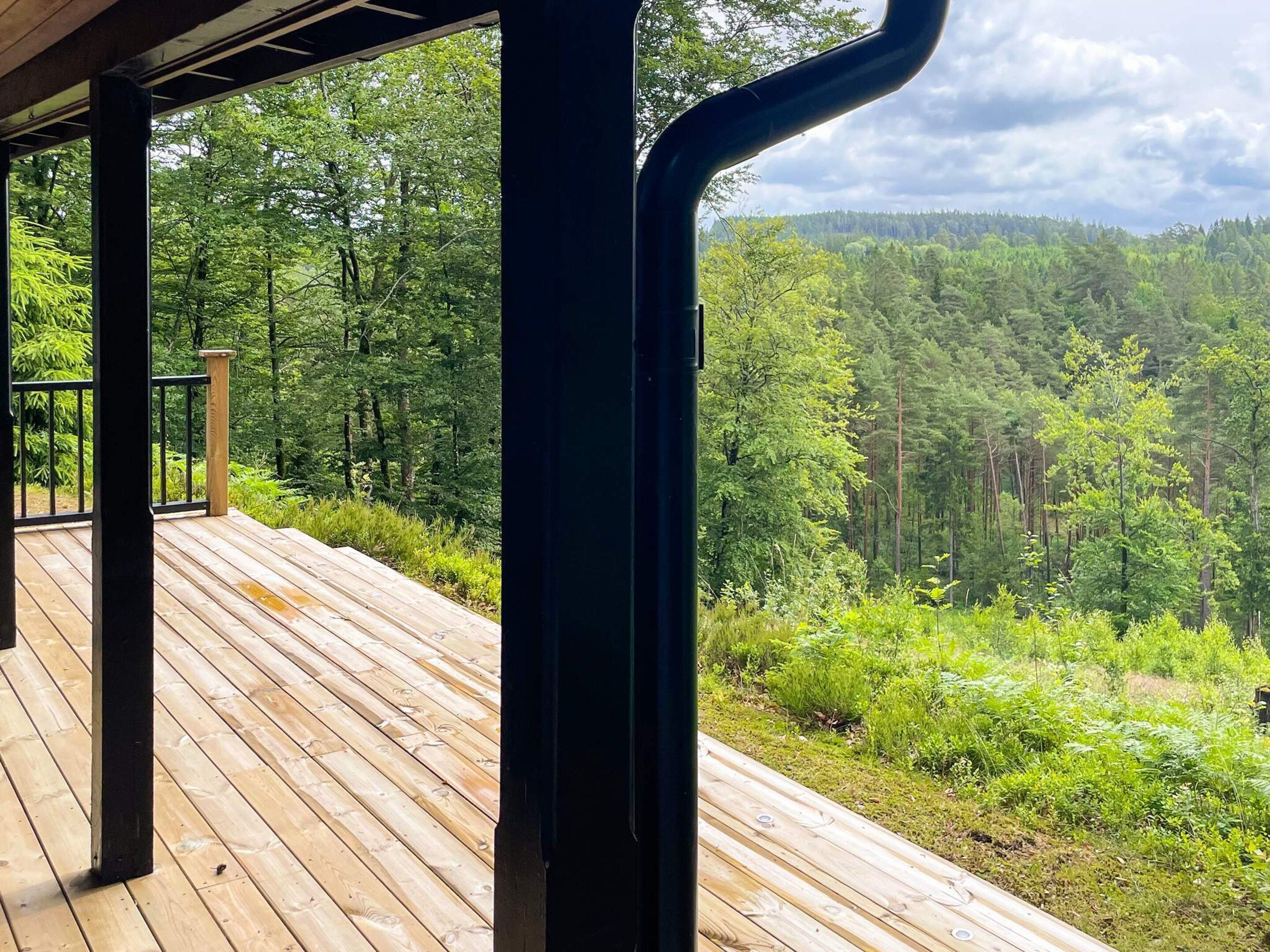 Una terraza de madera con vistas a zona boscosa.