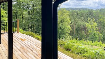 A wooden deck with a view of a forested area.