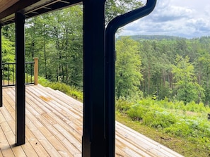 A wooden deck with a view of a forested landscape. - 4 Star Holiday Home in Knared (Knared)