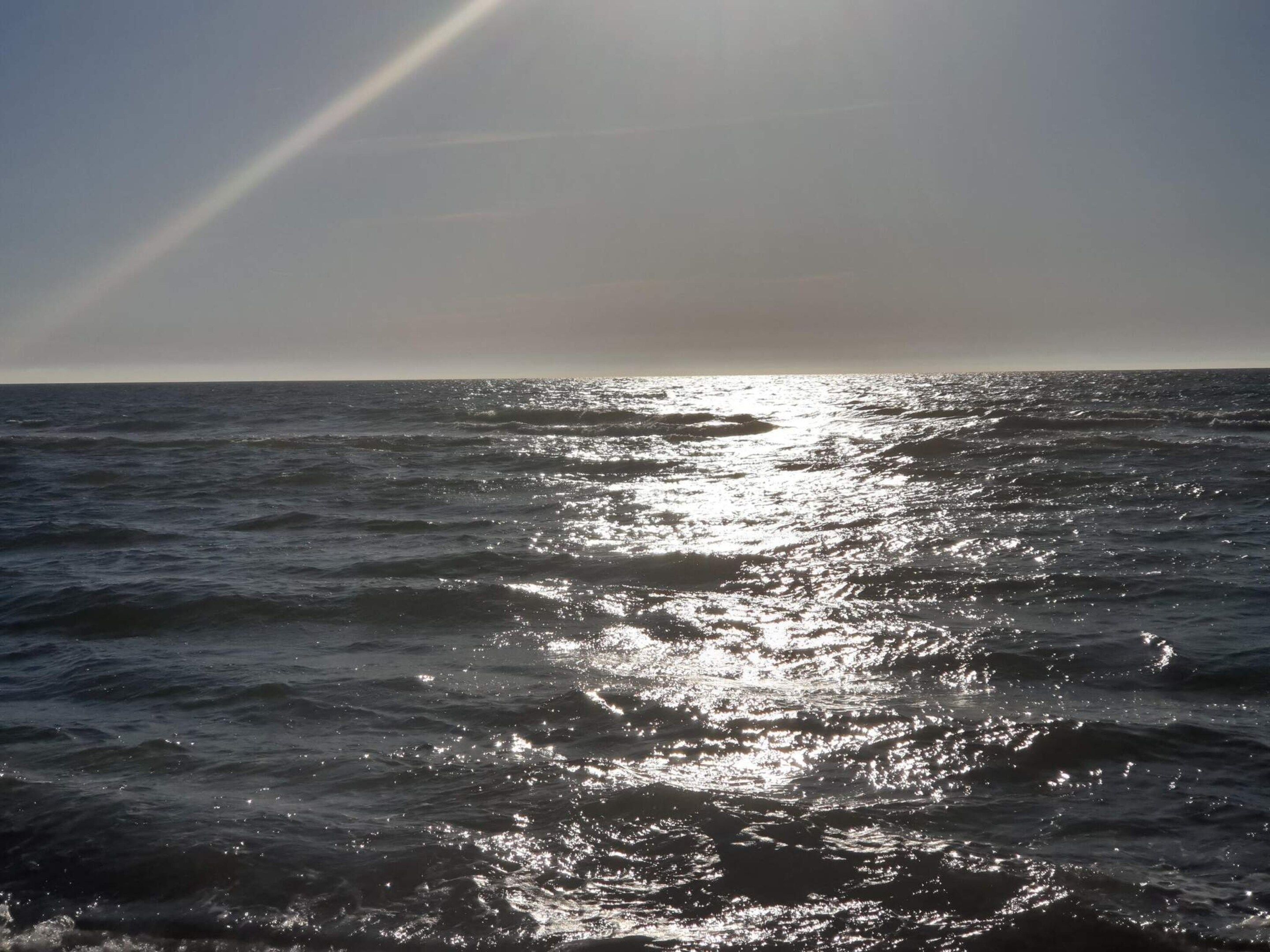 Une étendue d'eau dont la surface reflète la lumière du soleil.