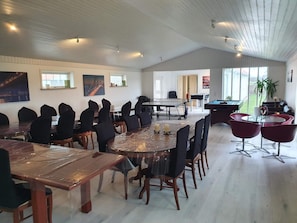 A spacious room with a large dining table, several chairs, a pool table, and a sofa area. - 5 Star Holiday Home in Lokken (Lokken)