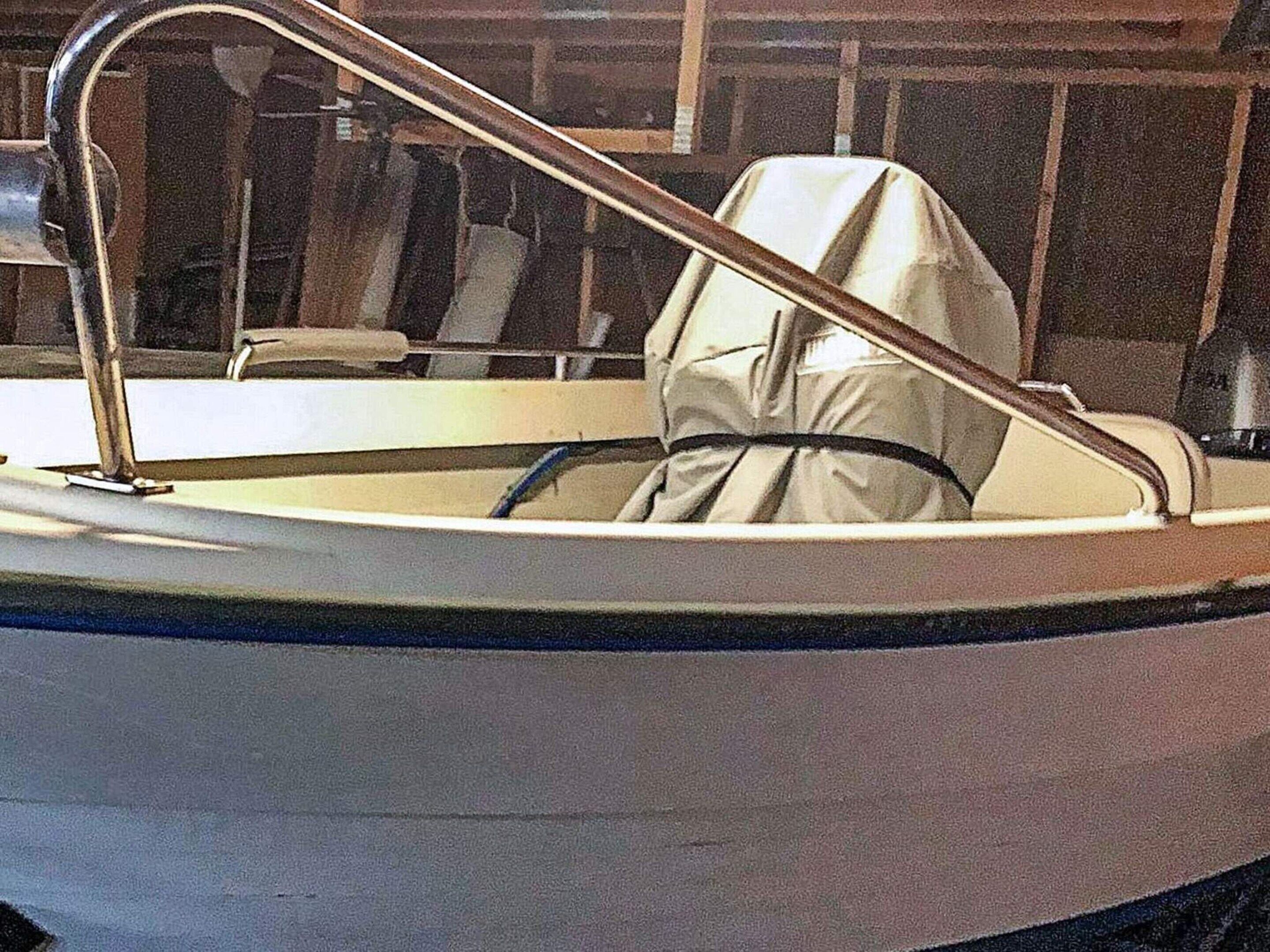 A boat with a covered seating area and a metal railing.