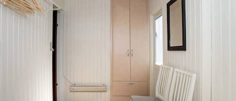 A bedroom with a bed, a bench, a wardrobe, and a window.