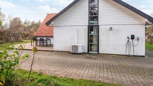 A single-story building with a sloped roof, a large window, and an air conditioning unit. - 6 Person Holiday Home in Skjern (Skjern)
