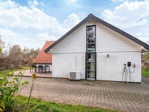 A single-story building with a sloped roof, a large window, and an air conditioning unit. - 6 Person Holiday Home in Skjern (Skjern)