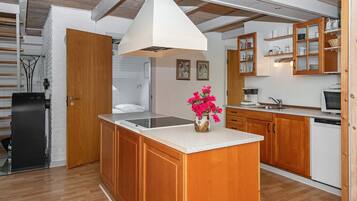 Una cocina moderna con armarios de madera, una isla central y encimera blanca.