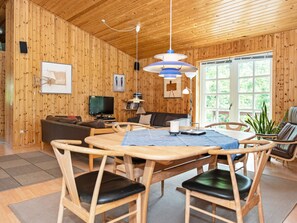 A wooden interior with a dining table, chairs, a sofa, and a television. - 6 Person Holiday Home in Kolind (Kolind)