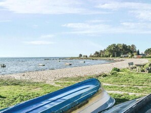 A beach with boats, a sandy shore, and a few buildings in the background. - 6 Person Holiday Home in Kolind (Kolind)