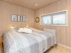 A bedroom with a bed, wooden walls, a window with blinds, and wall-mounted lights. - 9 Person Holiday Home in Humble (Sydlangeland)