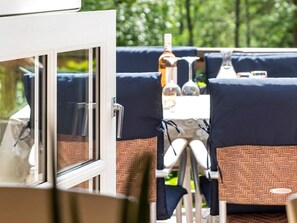 An outdoor dining area with a table set for two, surrounded by chairs with patterned cushions. - 8 Person Holiday Home in Skanes Fagerhult (Skånes Fagerhult)