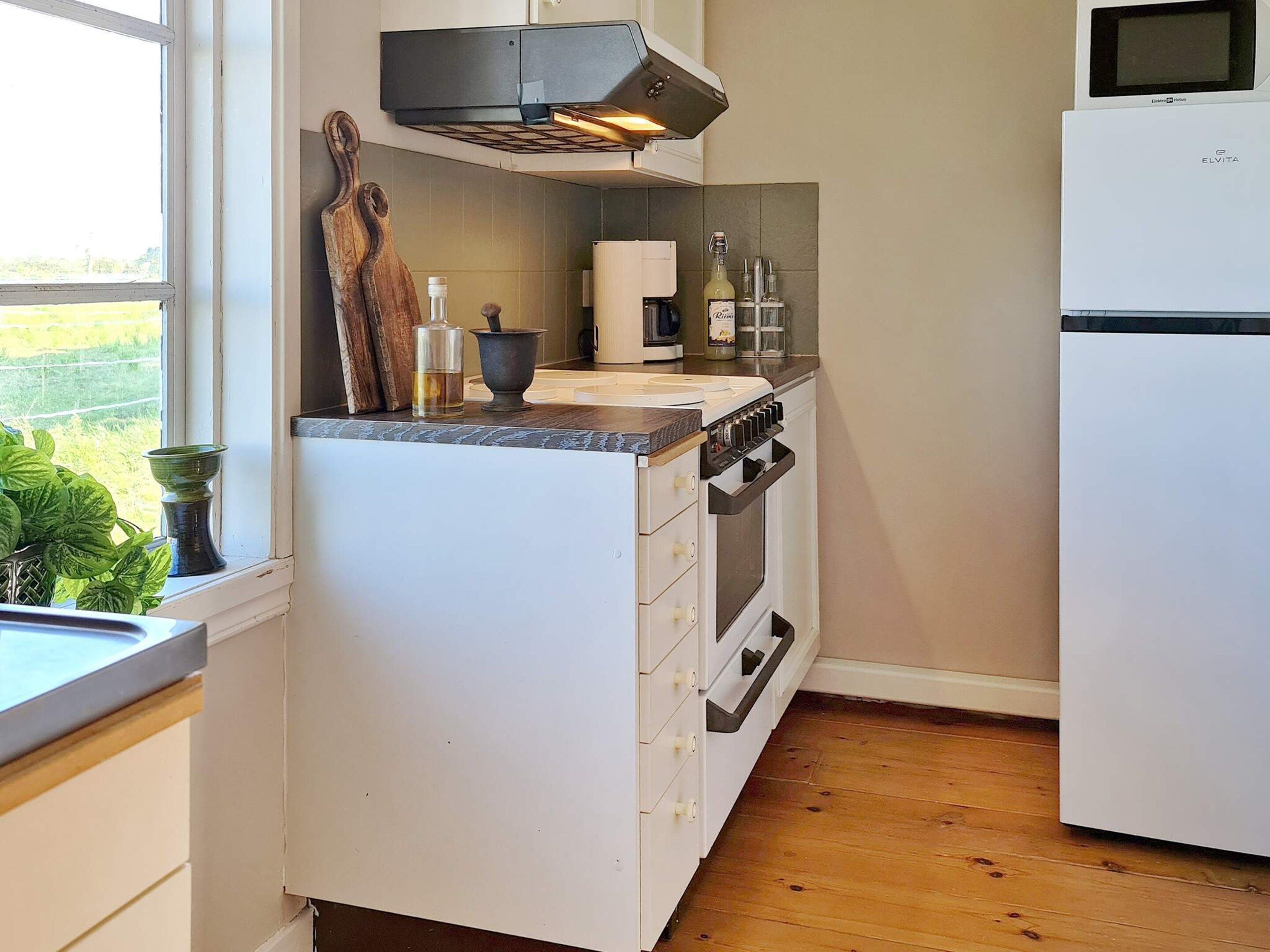 Una cocina equipada con horno empotrado, estufa, fregadero y refrigerador.