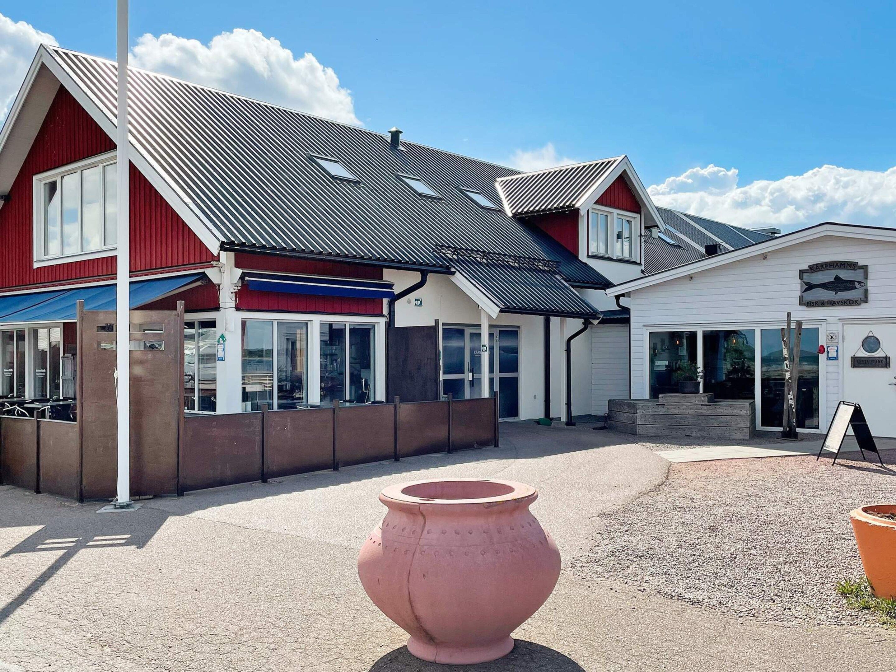 Un bâtiment à la façade rouge, doté d’un toit en métal et d’une enseigne indiquant qu’il s’agit d’un restaurant.