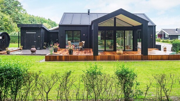 A modern house with a large deck, a conservatory, and a garage. - 6 Person Holiday Home in Juelsminde-by Traum (Horsens)
