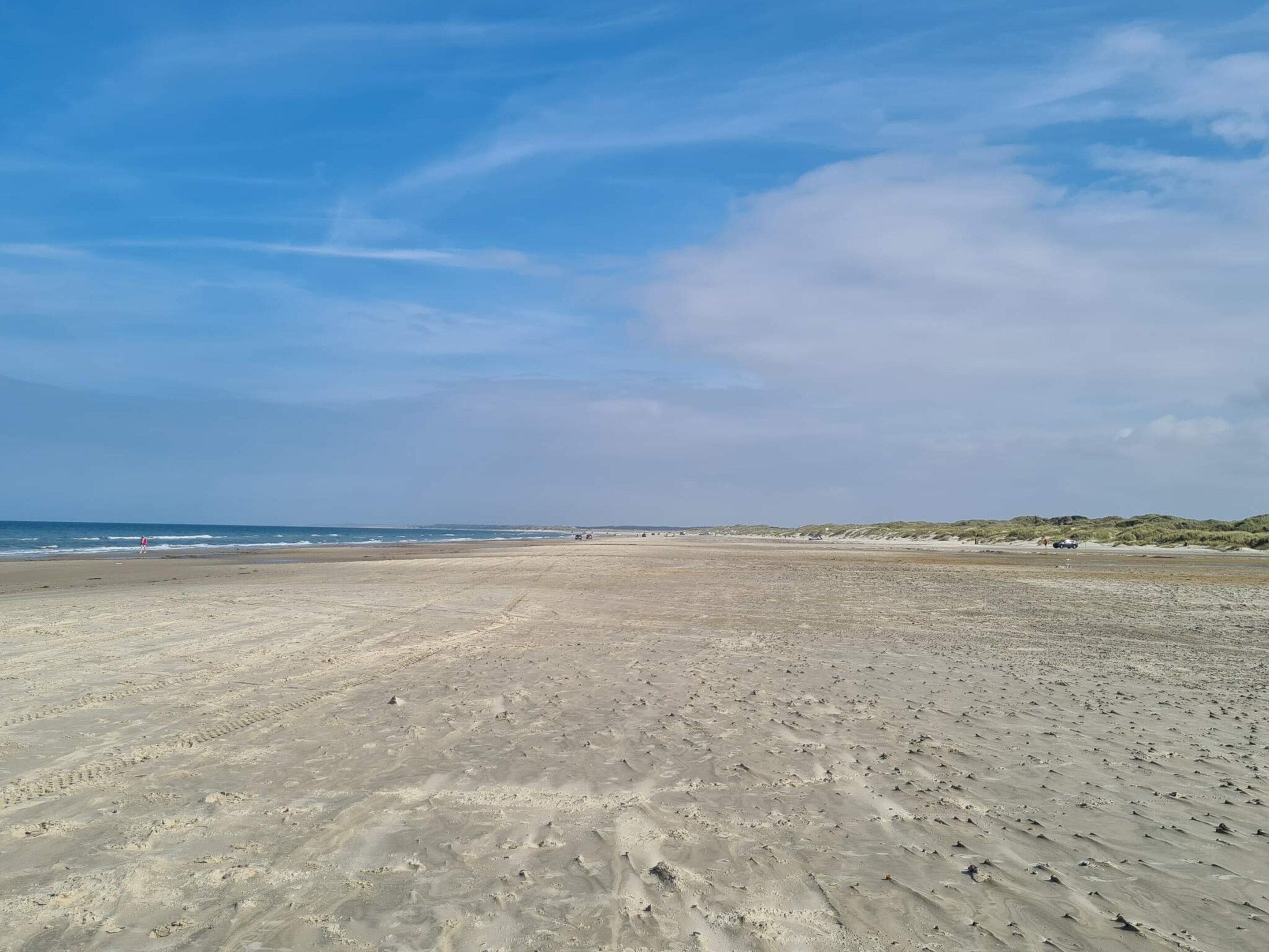A wide sandy beach with a clear sky.