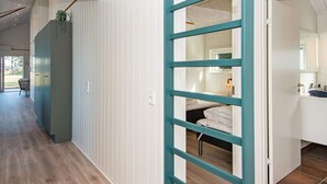 A modern interior with a wooden floor, a staircase, and a room with a bed and a bathroom. - 4 Star Holiday Home in Ansager (Ansager)