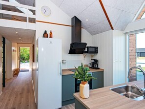A modern kitchen with a built-in microwave, a coffee maker, and a plant on the counter. - 4 Star Holiday Home in Ansager (Ansager)