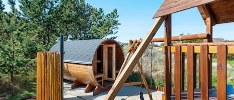A wooden play structure with a slide and a swing set.