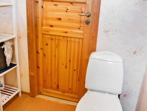 En trædør med et hvidt toilet ved siden af.