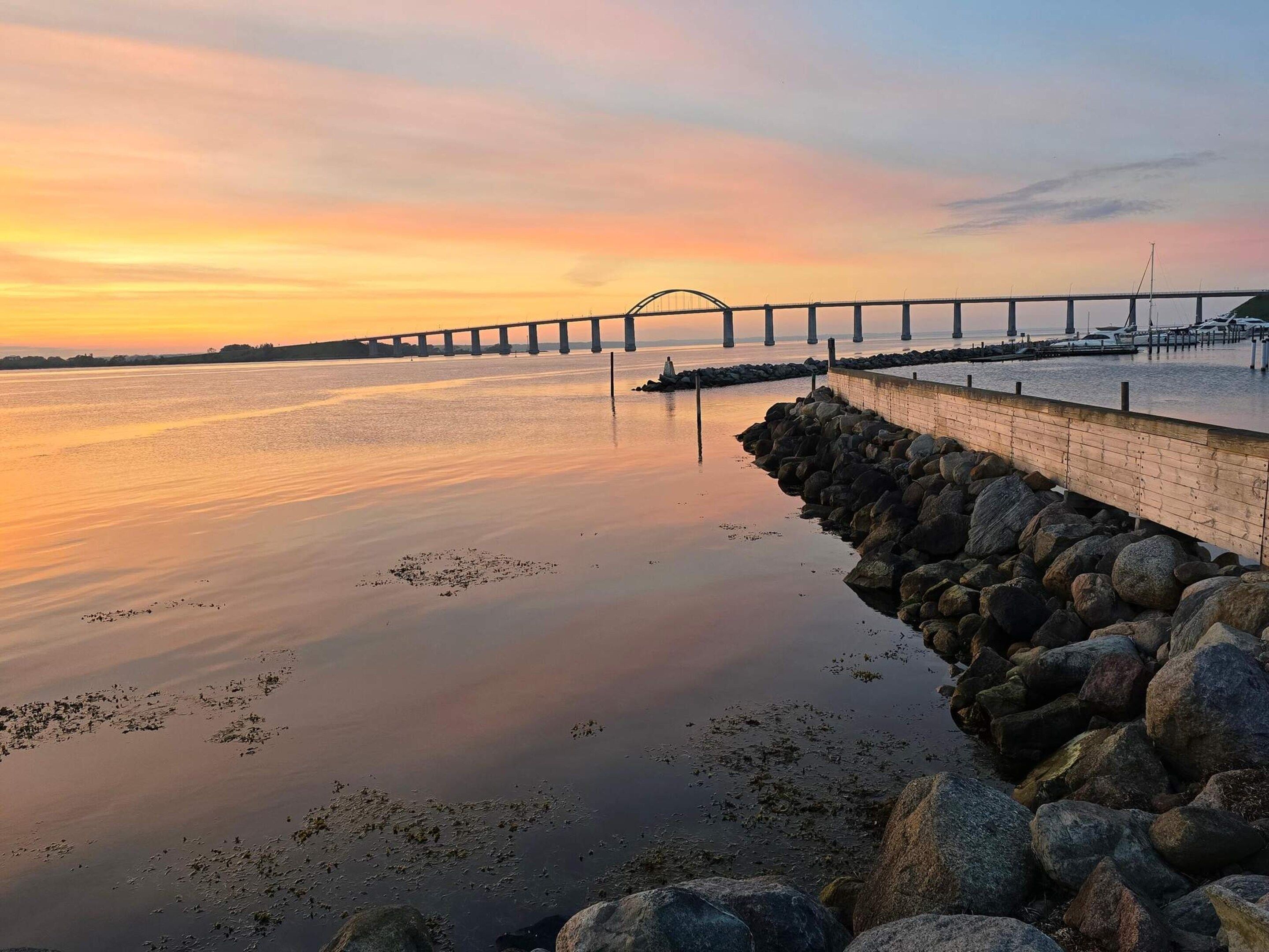 A calm waterfront with a bridge in the background.