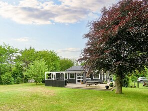 A house with a patio, a barbecue area, and a tree with red leaves. - 5 Person Holiday Home in Gilleleje (Gilleleje)
