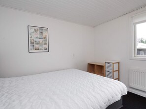 A bedroom with a bed, a framed picture on the wall, a window, and a radiator. - 5 Person Holiday Home in Gilleleje (Gilleleje)