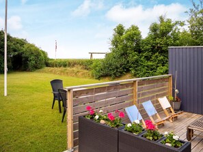A wooden deck with a seating area, a small table, and a garden with potted plants. - 6 Person Holiday Home in Hurup Thy (Hurup Thy)