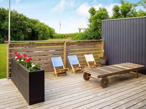 An outdoor deck with a wooden bench, two lounge chairs, and a planter with flowers. - 6 Person Holiday Home in Hurup Thy (Hurup Thy)