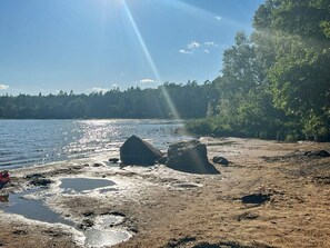 A natural landscape with a body of water, rocks, and a forested area. - 8 Person Holiday Home in Annerstad (Annerstad)
