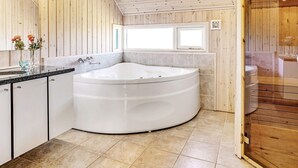 Une salle de bain moderne avec une baignoire sur pieds, un meuble-lavabo et une fenêtre située au-dessus de la baignoire.