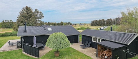 A property with three cabins, each with a separate entrance and a small porch. There is a large tree in the center.