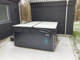 Un colchón portátil con funda, colocado al aire libre cerca de un edificio.