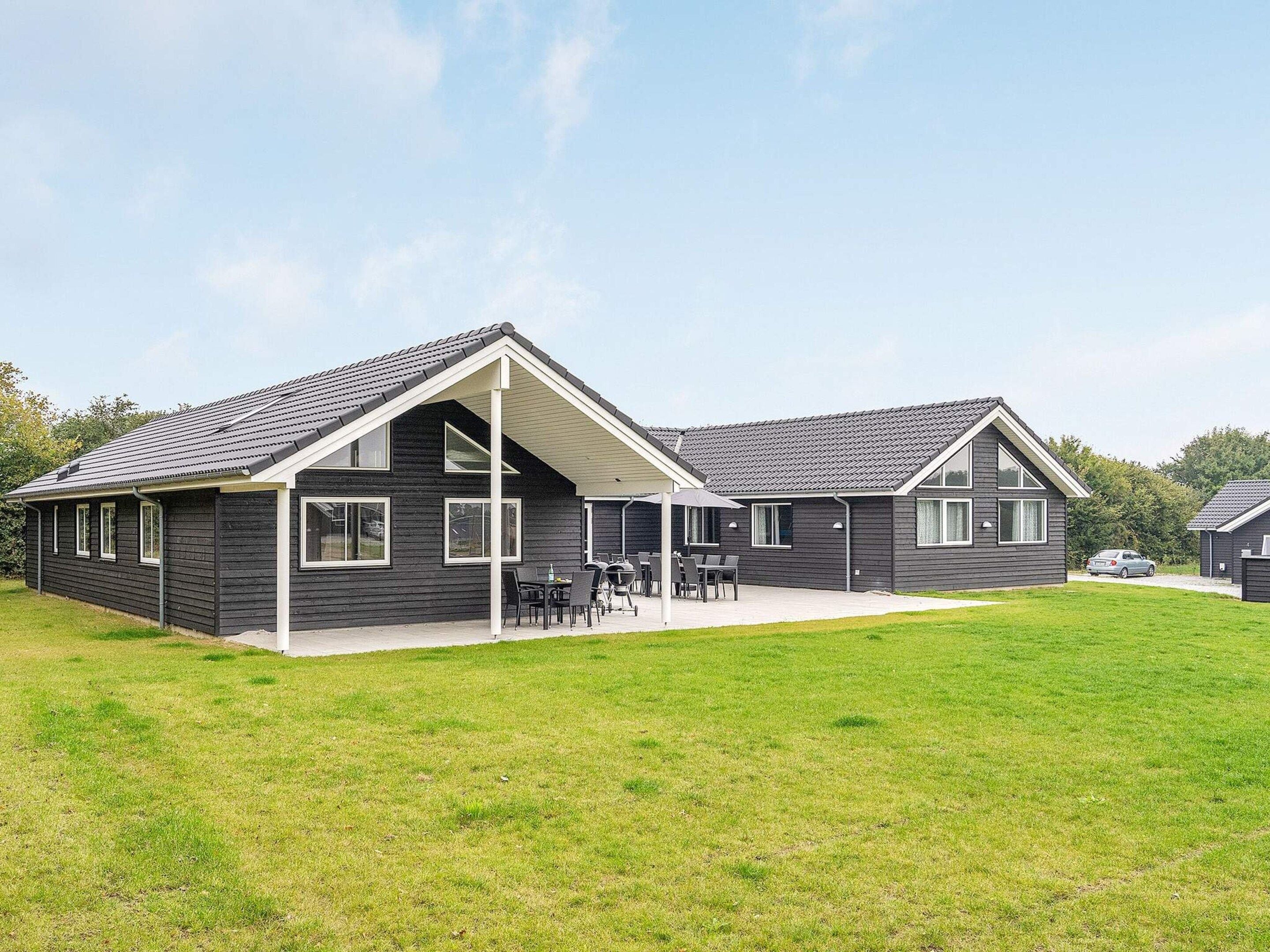 Een gebouw met twee verdiepingen, een plat dak en een overdekt terras.