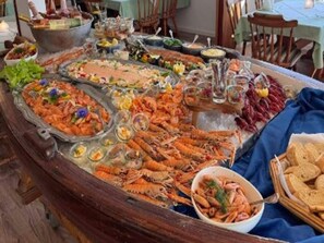 A seafood spread on a table with various dishes and glasses.