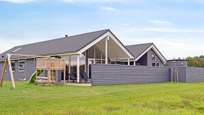 Imóvel residencial com varanda coberta, área de recreação e quintal cercado.