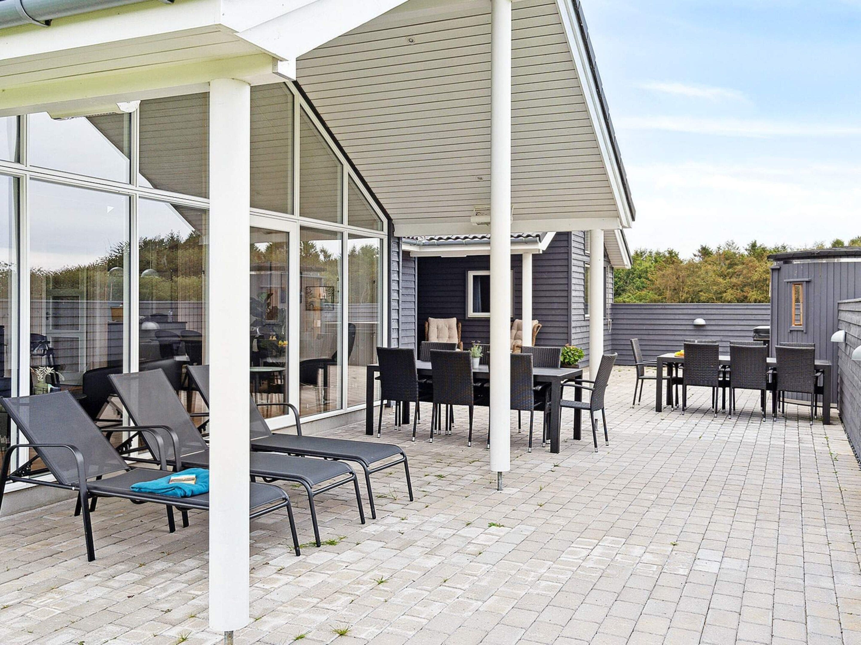 Un patio al aire libre con asientos y una parrilla.