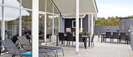 Un espace extérieur aménagé avec une terrasse, des sièges et un barbecue.
