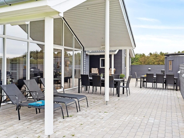 An outdoor patio area with seating and a grill.