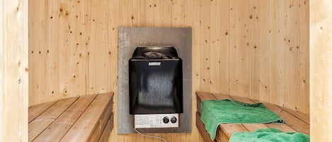 Un sauna con bancos de madera y equipo de sauna Harvia.