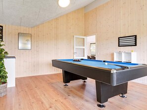 Taula de bitlles en una habitació amb parets de fusta i una làmpada al sostre.