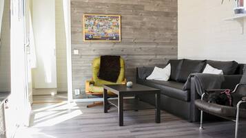 Una sala de estar moderna con un sofá, una silla, una mesa de centro y un cuadro en la pared.