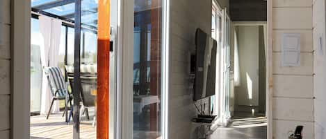 Un pasillo con una puerta de vidrio corrediza que da a una terraza exterior.