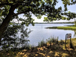 Une vue paisible sur le lac, avec un panneau indiquant un espace de pique-nique.